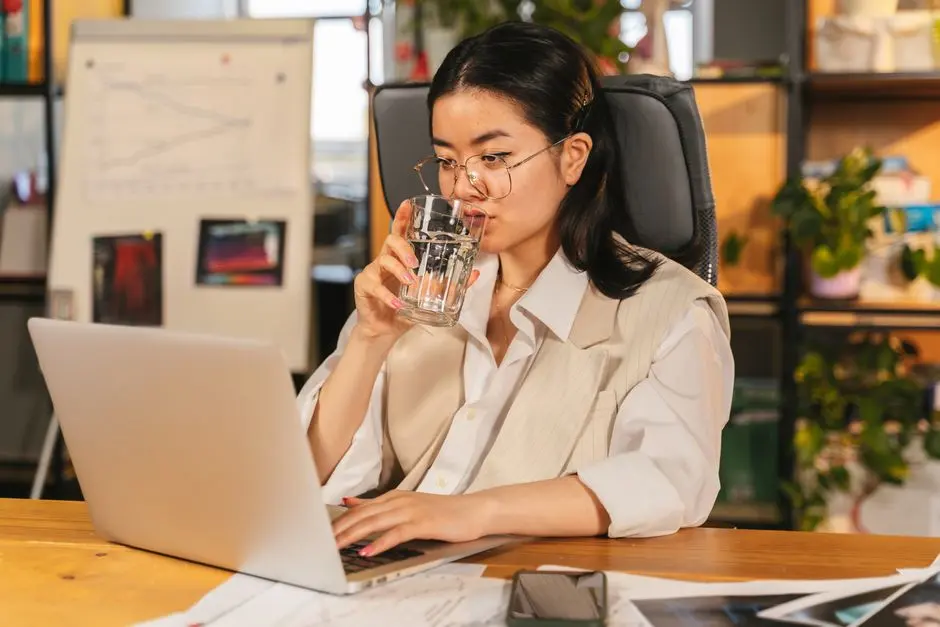 Ilustrasi pekerja kantor minum air putih di meja kerja